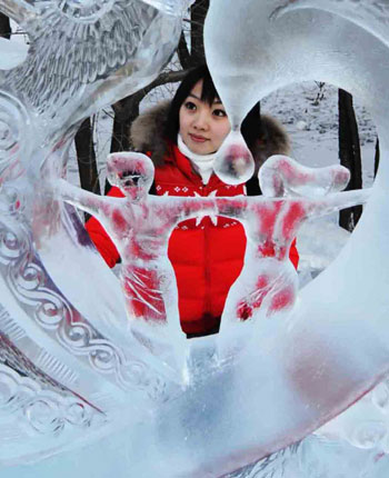 A visitor looks at an ice sculpture during the 23rd International Ice Sculpture Competition in Harbin, Northeast China's Heilongjiang Province, January 8, 2009. About 60 competitors from 12 countries and regions took part in this event which concluded on Thursday. [Xinhua]