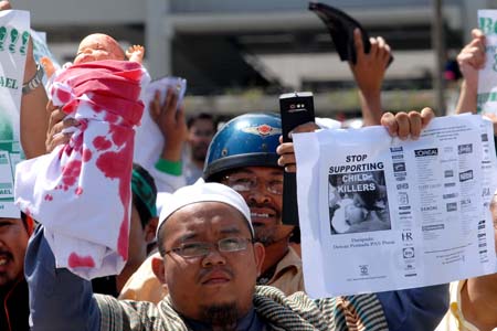 People hold a demonstration in front of the United States Embassy to Malaysia to protest against the US support for Israel's continued military attacks on the Palestinians in the Gaza Strip, in Kuala Lumpur, Jan. 9, 2009. [Chong Voon Chung/Xinhua]