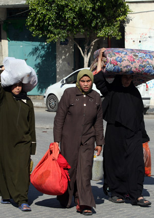 Palestinian women leave their homes after Israel's offensive in Gaza, Jan. 9, 2009. [Xinhua]