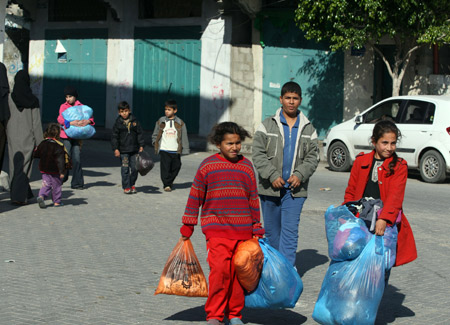 Palestinians leave their homes after Israel's offensive in Gaza, Jan. 9, 2009. [Xinhua]