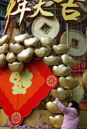 A girl stands near a decoratin celebrating the Spring Festival, or the Chinese lunar New Year, which falls on Jan. 26 this year, in Shanghai, east China, Jan. 9, 2009. [Xinhua]