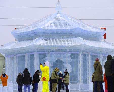 Tourists view a snow sculpture depicting an ancient Chinese palace, during the 2009 Shenyang International Ice and Snow Festival in Shenyang, capital of northeast China's Liaoning Province, on Jan. 11, 2009. The 35-day festival, featuring ice lanterns, snow sports and traditional Chinese elements, was opened here on Sunday. [Xinhua]