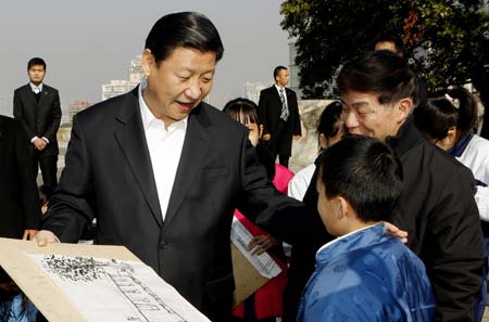 Chinese Vice President Xi Jinping (1st L) talks with a child practising painting during his visit to historic site of Mount Fortress in Macao, south China, Jan. 11, 2009.[Xinhua]