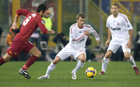 AC Milan's David Beckham (C) and his teammate Gianluca Zambrotta (R) challenges Mirko Vucinic of AS Roma during their Italian Serie A soccer match at the Olympic stadium in Rome Jan. 11, 2009. [Xinhua/Reuters]