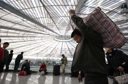 A passenger carrying his luggage walks into the waiting room of the Shanghai South Railway Station in Shanghai, east China, Jan. 11, 2009. The 40-day Spring Festival transportation, or Chunyun in Chinese, began on Sunday, with the estimation of 2.32 billion people to travel over the Chinese lunar New Year starting from Jan. 26 this year. [Xinhua] 