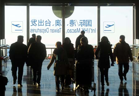 Travelers enter Terminal 3 of Capital International Airport in Beijing, capital of China, on Jan. 11, 2009. The 40-day Spring Festival transportation, or Chunyun in Chinese, began on Sunday, with the estimation of 2.32 billion people to travel over the Chinese lunar New Year starting from Jan. 26 this year. [Xinhua] 