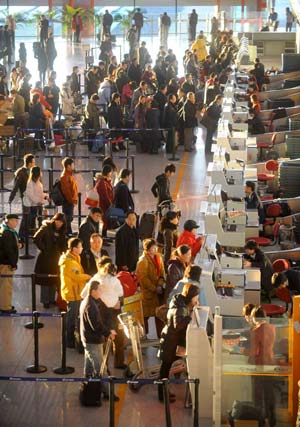 Passengers wait to check in at Terminal 3 of Capital International Airport in Beijing, capital of China, on Jan. 11, 2009. The 40-day Spring Festival transportation, or Chunyun in Chinese, began on Sunday, with the estimation of 2.32 billion people to travel over the Chinese lunar New Year starting from Jan. 26 this year.[Xinhua] 