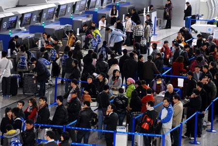 Passengers wait to check in at Pudong International Airport in Shanghai, east China, Jan. 11, 2009. The 40-day Spring Festival transportation, or Chunyun in Chinese, began on Sunday, with the estimation of 2.32 billion people to travel over the Chinese lunar New Year starting from Jan. 26 this year. [Xinhua] 