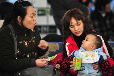 A mother takes care of her child at the Guangzhou Railway Station in Guangzhou, capital city of south China's Guangdong Province, on Jan. 11, 2009. The 40-day Spring Festival transportation, or Chunyun in Chinese, began on Sunday, with the estimation of 2.32 billion people to travel over the Chinese lunar New Year starting from Jan. 26 this year.[Xinhua] 