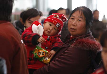 Guo Bei and her grandmother wait for a train at the Shanghai South Railway Station in Shanghai, east China, Jan. 11, 2009. The 40-day Spring Festival transportation, or Chunyun in Chinese, began on Sunday, with the estimation of 2.32 billion people to travel over the Chinese lunar New Year starting from Jan. 26 this year.[Xinhua] 