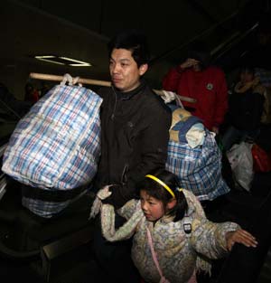 Travelers walk to enter the Beijing West Railway Station in Beijing, capital of China, on Jan. 11, 2009. The 40-day Spring Festival transportation, or Chunyun in Chinese, began on Sunday, with the estimation of 2.32 billion people to travel over the Chinese lunar New Year starting from Jan. 26 this year. [Xinhua] 