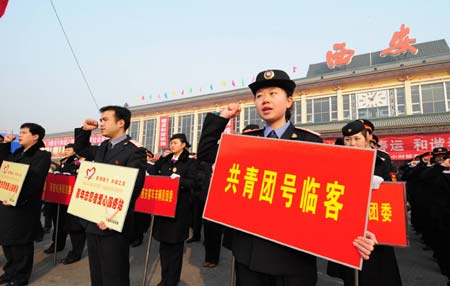 Volunteers swear during the starting ceremony of a service activity at the Xi'an Railway Station in Xi'an, capital of northwest China's Shaanxi Province, Jan. 11, 2009. More than 5,000 volunteers of the Xi'an Railway Bureau will provide services to passengers during the Spring Festival travel season.[Xinhua] 