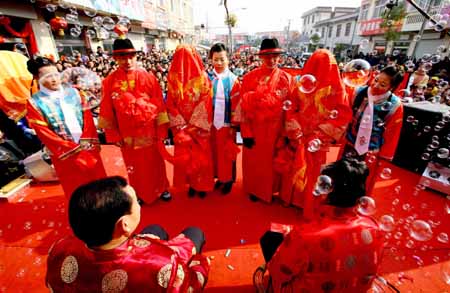 Bridegrooms Li Guanglong and Li Guangbiao, who are twins, prepare to salute with their brides during a wedding ceremony in the Chinese traditional manner in Donghai County, east China's Jiangsu Province, Jan. 11, 2009. The twin brothers held weddings together in the Chinese traditional manner Sunday.[Zhu Guilin/Xinhua]