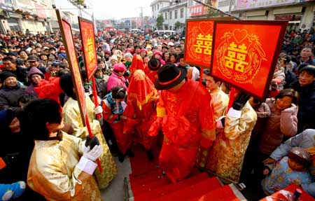 Bridegrooms Li Guanglong and Li Guangbiao, who are twins, lead their brides during a wedding ceremony in the Chinese traditional manner in Donghai County, east China's Jiangsu Province, Jan. 11, 2009. [Zhu Guilin/Xinhua]