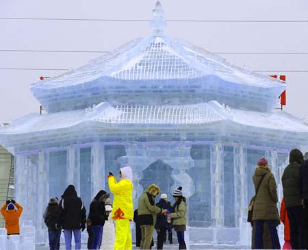 Tourists view a snow sculpture depicting an ancient Chinese palace, during the 2009 Shenyang International Ice and Snow Festival in Shenyang, capital of northeast China's Liaoning Province, on Jan. 11, 2009. The 35-day festival, featuring ice lanterns, snow sports and traditional Chinese elements, was opened here on Sunday. [Ren Yong/Xinhua]