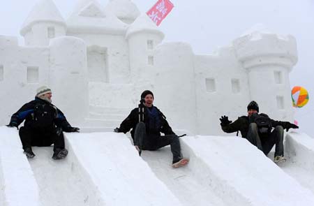 Three German tourists have fun on a snow slide during the 2009 Shenyang International Ice and Snow Festival in Shenyang, capital of northeast China's Liaoning Province, on Jan. 11, 2009. The 35-day festival, featuring ice lanterns, snow sports and traditional Chinese elements, was opened here on Sunday. [Ren Yong/Xinhua] 