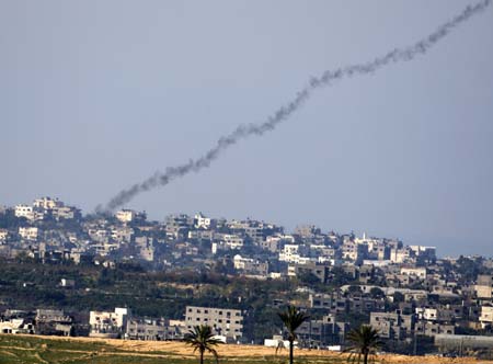 A trail of smoke is seen after the launch of a rocket from the northern Gaza Strip towards Israel January 10, 2009. Israeli tanks advanced on Gaza and Hamas militants fired rockets at Israel on Saturday, as both sides ignored international calls to stop the conflict and Israel warned it would escalate its assault.