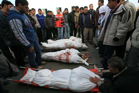 Palestinians mourn over the victims killed by Israeli attacks in front of the morgue at al-Shifa hospital in Gaza City, Jan. 11, 2009. The Israeli army continued its air and ground strikes on different targets in the Gaza Strip from midnight to Sunday morning, killing 24 Palestinians, local medical sources and witnesses said. (Xinhua/Wissam Nassar)