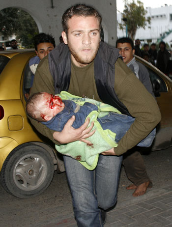 A Palestinian child wounded during Israeli strikes is sent to Shifa hospital in Gaza City on Jan. 11, 2009. Israel's ongoing attacks on Hamas targets in the Gaza Strip have claimed almost 900 lives. [Xinhua]