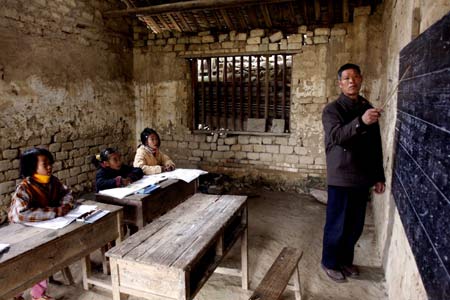 Xu Zhenguang (1st R), gives a lesson at the four-person primary school of Siliu Village in Rongshui County, southwest China's Guangxi Zhuang Autonomous Region, Jan. 12, 2009. Only 3 pupils were still attending the school while others left with their migrant-worker parents in recent years. Mr. Xu, who has been a teacher for 37 years, stuck to his job at the four-person school. [Long Tao/Xinhua]