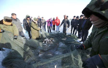 Fishermen catch fish on the Ulunggur Lake in Fuhai County, northwest China's Xinjiang Uygur Autonomous Region, Jan 8, 2009. The traditional winter halieutics bring considerable incomes to local fishmen, and boosts the tourism around the Ulunggur Lake as well. [Sadat/Xinhua]