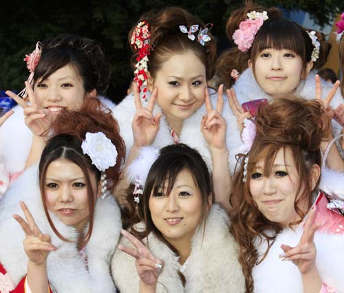 Japanese twenty-year-olds dressed in traditional kimonos pose for photos after attending a ceremony to celebrate the annual Coming-of-Age Day at the Tokyo Disneyland in Urayasu City of Chiba Prefecture, suburban Tokyo, on Jan. 12, 2009.