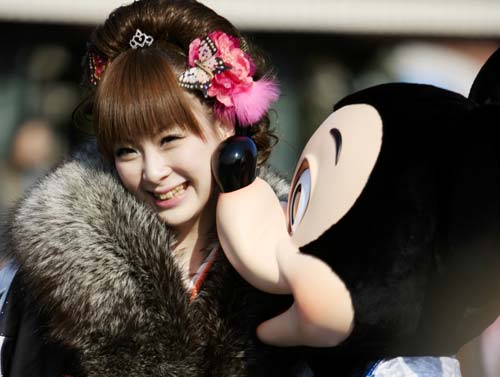 Mickey Mouse kisses a Japanese kimono-dressed twenty-year-old girl during a ceremony to celebrate the annual Coming-of-Age Day at the Tokyo Disneyland in Urayasu City of Chiba Prefecture, suburban Tokyo, on Jan. 12, 2009.[Xinhua]