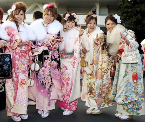 Japanese twenty-year-olds dressed in traditional kimonos pose for photos after attending a ceremony to celebrate the annual Coming-of-Age Day at the Tokyo Disneyland in Urayasu City of Chiba Prefecture, suburban Tokyo, on Jan. 12, 2009.[Xinhua]