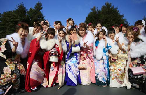 Japanese twenty-year-olds dressed in traditional kimonos pose for photos after attending a ceremony to celebrate the annual Coming-of-Age Day at the Tokyo Disneyland in Urayasu City of Chiba Prefecture, suburban Tokyo, on Jan. 12, 2009.[Xinhua]