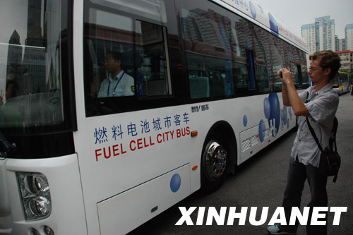A Photo from July 29, 2008. A young foreigner takes a photo of a fuel cell city bus in Beijing. During the Beijing Olympic Games, a number of clean fuel buses were brought into service in China. 