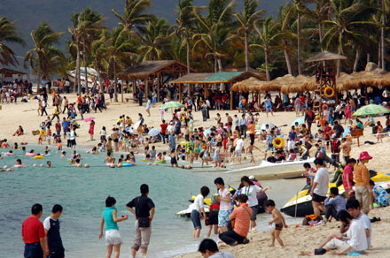 Tourists relax on a beach in Sanya, Hainan. The province is aiming to become a top international beach resort.[File photo] 