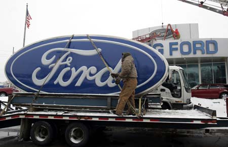 Workers remove the Ford logo signs from Al Long Ford auto dealership in Warren, Michigan Dec. 23, 2008.[Xinhua]