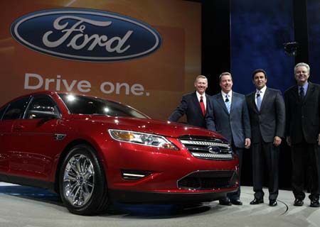 Ford Motor Co. Chief Executive and President Alan Mulally (L), Executive Chairman Bill Ford (2nd L), President of the Americas Mark Fields and Group Vice President of Product Development Derrick Kuzak (R) pose next to the 2010 Taurus sedan during press days at the North American International Auto Show in Detroit, Michigan, Jan. 11, 2009.