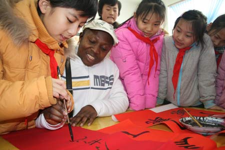 Foreign teacher Del learns to write the spring couplets under a student's guide at Boxing County, east China's Shandong Province, Jan. 11, 2009, to welcome the forthcoming Chinese traditional Spring Festival which falls on Jan. 26 this year. 