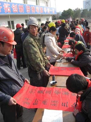 Children from a calligraphy training class write spring couplets for the laborers on a construction site in Chaohu City, east China's Anhui Province, Jan. 11, 2009, to welcome the forthcoming Chinese traditional Spring Festival which falls on Jan. 26 this year. 