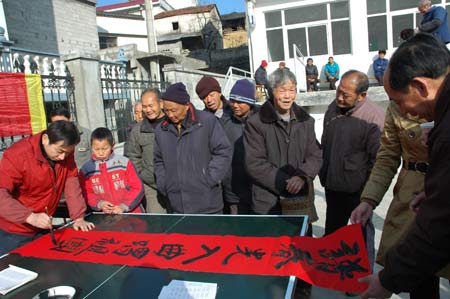 A folk calligrapher writes spring couplets for the local residents in Tangkou Township, east China's Anhui Province, Jan. 11, 2009, to welcome the forthcoming Chinese traditional Spring Festival which falls on Jan. 26 this year. 