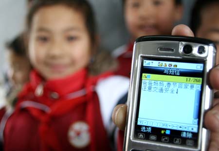 A girl shows a messages written for her parents about the traffic safety on their way home at Guanzhen primary school in Hanshan County, east China's Anhui Province, Jan. 13, 2009. Traffic policemen in the county help children send messages to their parents who work in other cities to remind them of traffic safety before the Chinese traditional Spring Festival.[Cheng Qianjun/Xinhua]