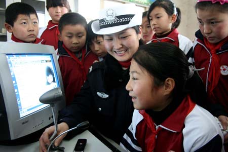 Li Tingting (front) reminds her migrant-worker parents, who work in Beijing, of the traffic safety via the video chat service at Guanzhen primary school in Hanshan County, east China's Anhui Province, Jan. 13, 2009. Traffic policemen in the county help children send messages to their parents who work in other cities to remind them of traffic safety before the Chinese traditional Spring Festival.[Cheng Qianjun/Xinhua]