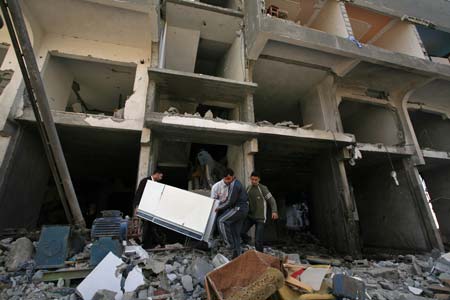 Palestinians fetch living articles from their houses destroyed by Israeli strikes in the al Karama area of Gaza City on Jan. 13, 2009. Israeli soldiers fought heavy battles with local militants in Gaza early Tuesday. Medics said Monday that over 900 people have been killed and more than 4,100 others wounded since Israeli military operation on Dec. 27, 2008. [Wissam Nassar/Xinhua]