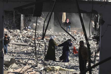 Palestinians inspect their houses destroyed by Israeli strikes in Gaza City on Jan. 13, 2009. Israeli soldiers fought heavy battles with local militants in Gaza early Tuesday. Medics said Monday that over 900 people have been killed and more than 4,100 others wounded since Israeli military operation on Dec. 27, 2008. [Wissam Nassar/Xinhua]