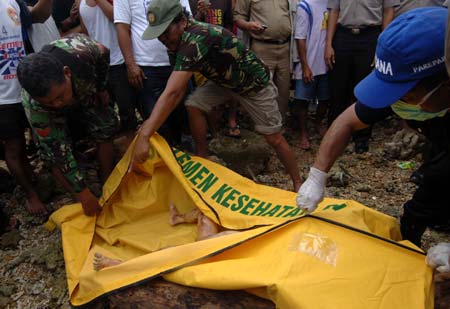 Rescuers wrap the body of a baby who died in the ferry sinking accident near Pare-Pare port, Sulawesi Island, Indonesia, on Jan. 13, 2009. Rescuers found the first body of baby victims in this accident on Tuesday. 