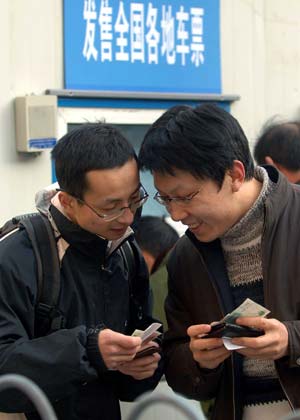 Two men chat after buying tickets at the Beijing West Railway Station in Beijing, capital of China, Jan. 13, 2009, as the traditional Chinese Lunar New Year approaches.[Gong Lei/Xinhua]