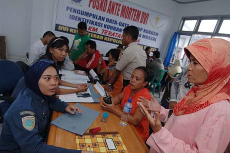 A woman provides the information of her relative missing in the ferry sinking accident to police at the disaster victim identification center in the Pare-Pare port, Sulawesi Island, Indonesia, on Jan. 13, 2009. 