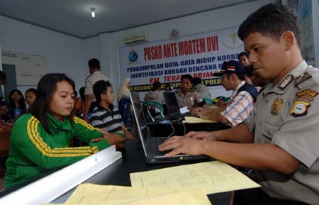 A woman provides the information of her relative missing in the ferry sinking accident to police at the disaster victim identification center in the Pare-Pare port, Sulawesi Island, Indonesia, on Jan. 13, 2009.