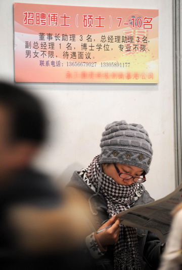 A woman reads a leaflet of want ads at a job fair for college graduates at Hangzhou Peace International Convention and Exhibition Center in Hangzhou, east China's Zhejiang province January 13, 2009. [Xinhua]