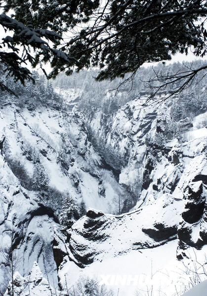 A snow covered gorge runs along Changbai Mountain in northeast China's Jilin Province in this photo taken on January 12, 2009. The white snow stands stark in contrast with black pines, making a picturesque scene in this renowned famous tourist resort. [Photo: Xinhuanet]