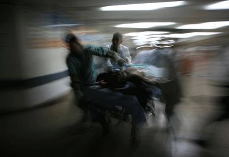 Palestinian medics wheel a wounded man, who was hurt in an Israeli strike, to Shifa hospital in Gaza City, Jan. 13, 2009.[Xinhua]