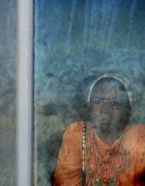 A woman waits for the news of missing relatives who were on the sinking Teratai Prima ferry, in Parepare of South Sulawesi, Indonesia, Jan. 14, 2009. The Indonesian government assumed that there was a false data in the manifest of the ship, more passengers may be aboard the sunken ship. [Yue Yuewei/Xinhua]