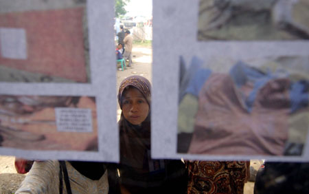 People check photos of two victims of the Teratai Prima ferry sinking, in Parepare of South Sulawesi, Indonesia, Jan. 14, 2009.[Yue Yuewei/Xinhua]