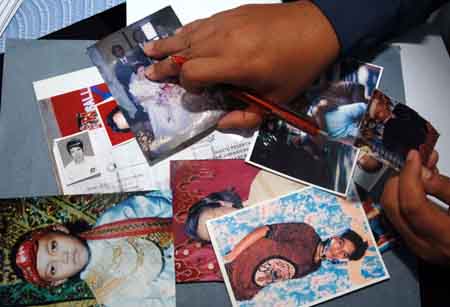 A rescue official checks photos of missing passengers who were on the sinking Teratai Prima ferry, in Parepare of South Sulawesi, Indonesia, Jan. 14, 2009.[Yue Yuewei/Xinhua]